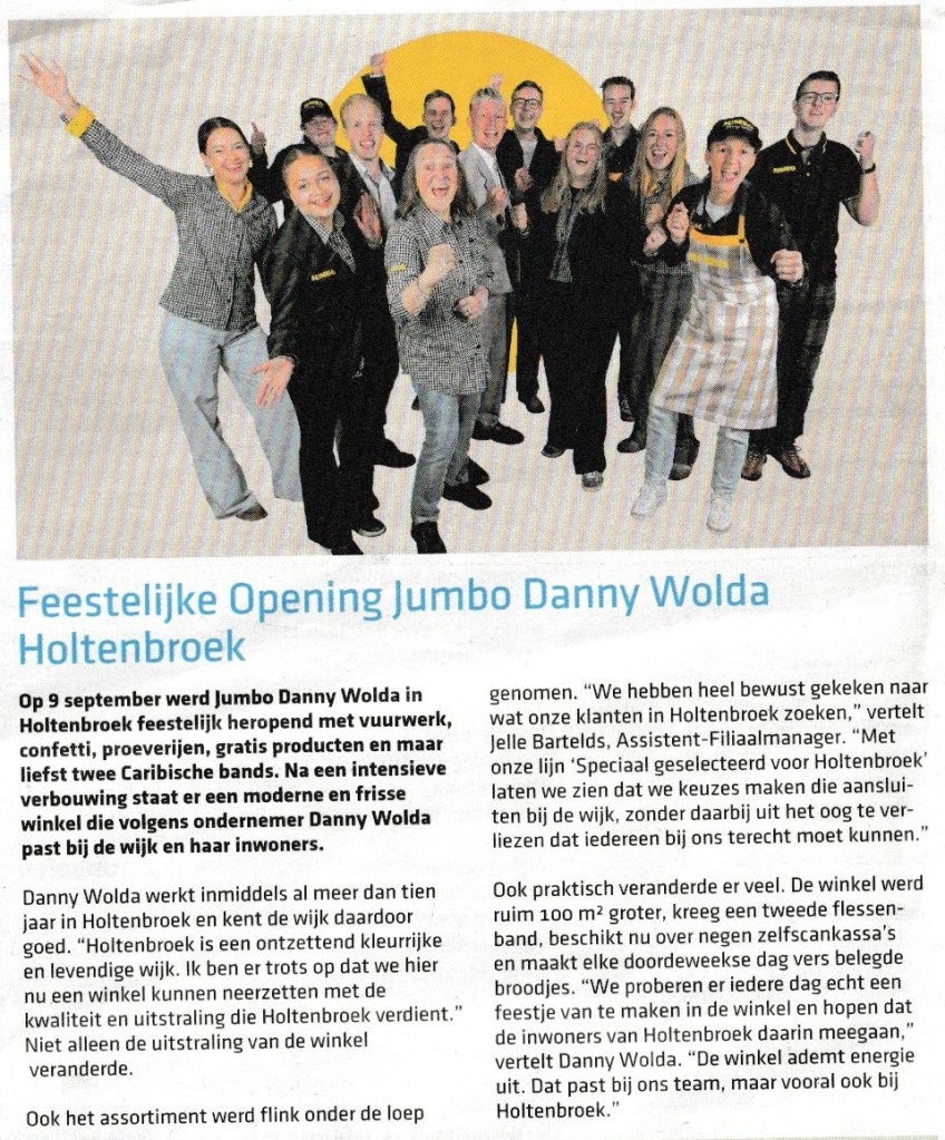 Groep enthousiaste medewerkers tijdens de feestelijke opening van Jumbo Danny Wolda in Holtenbroek, met feestelijk decor en opgetogen gezichten.